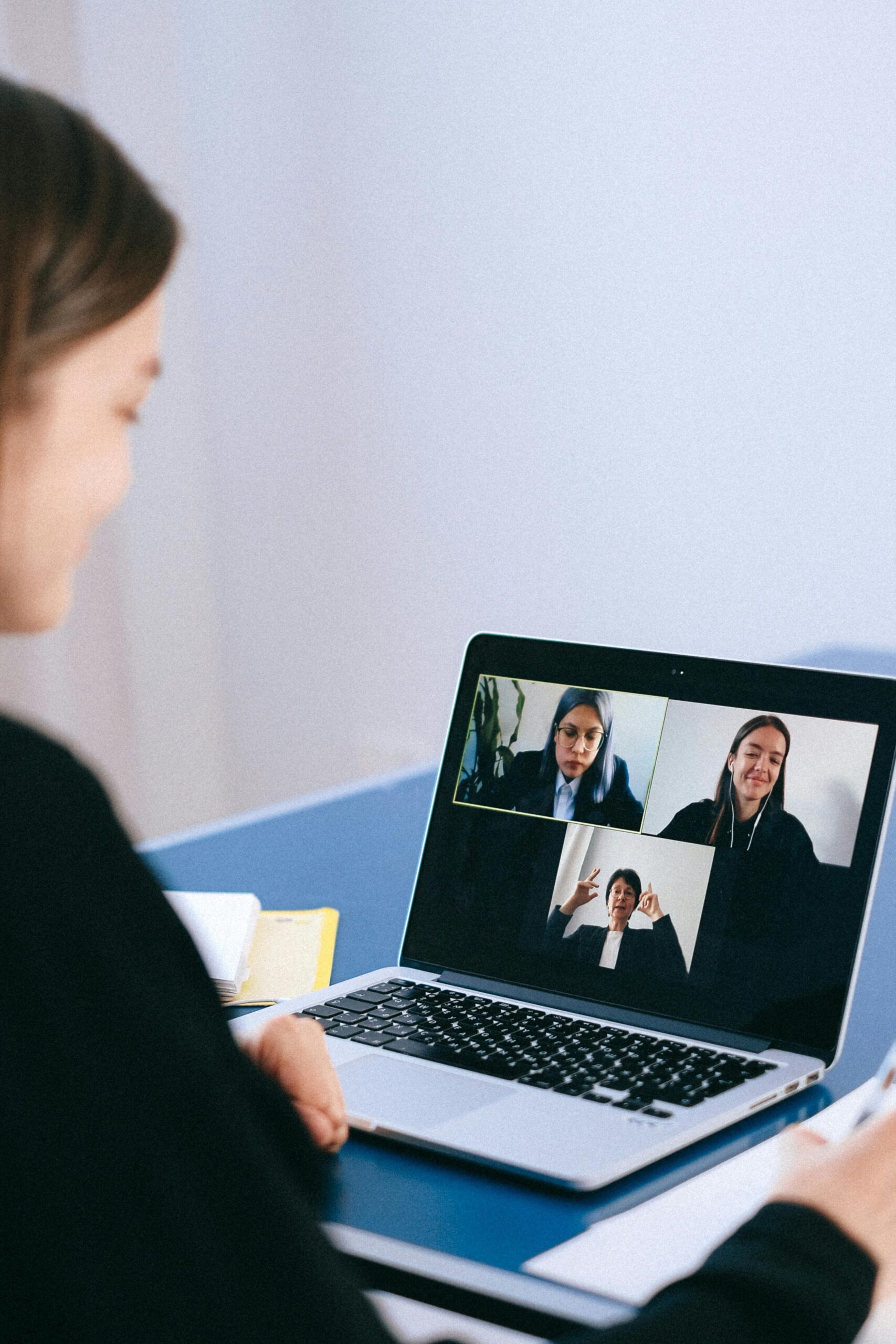 pexels-photo-4226122-4226122 A woman participates in a virtual meeting with colleagues via video call on a laptop.